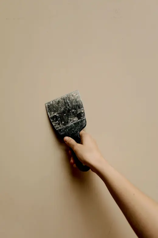 Espátula aplicando massa na parede (imagem ilustrativa)